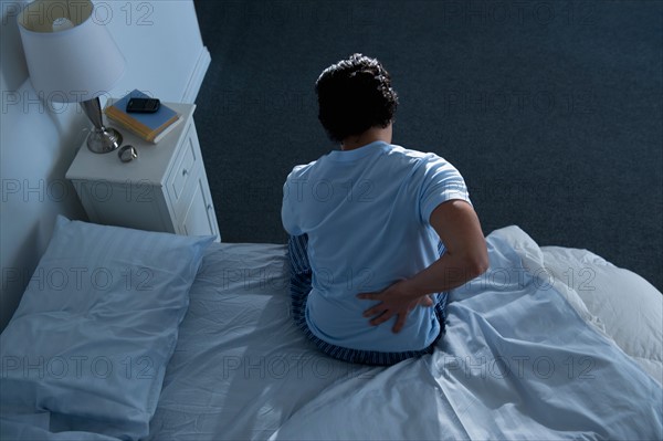 Man sitting on bed .