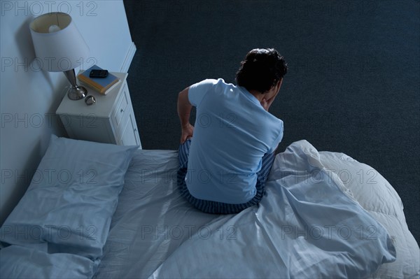 Man sitting on bed .