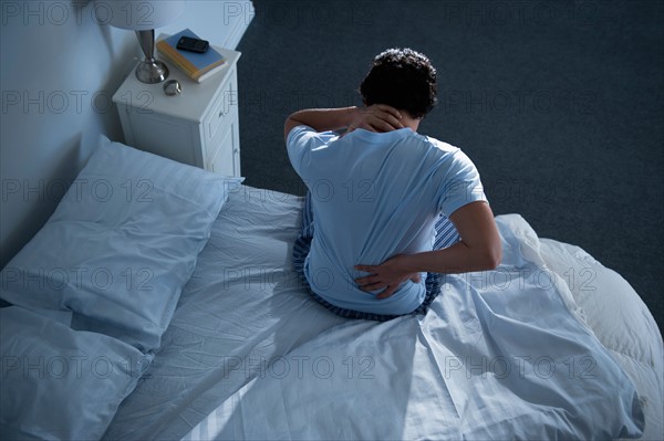 Man sitting on bed .