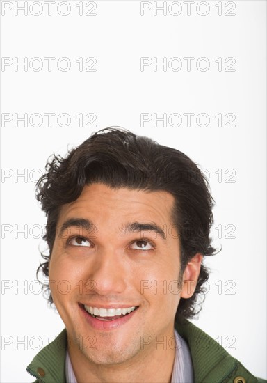 Studio shot of young man looking up.