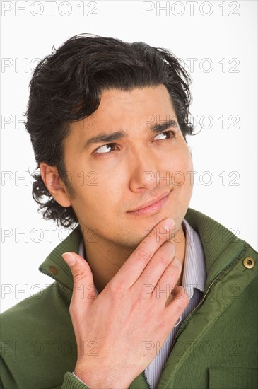 Studio shot of young man looking confused.