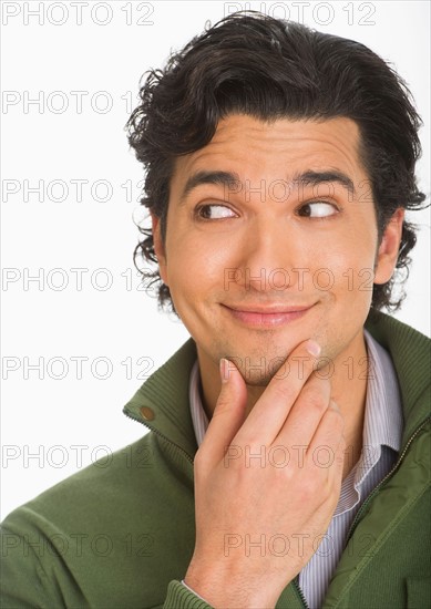 Studio shot of young man looking surprised and happy.