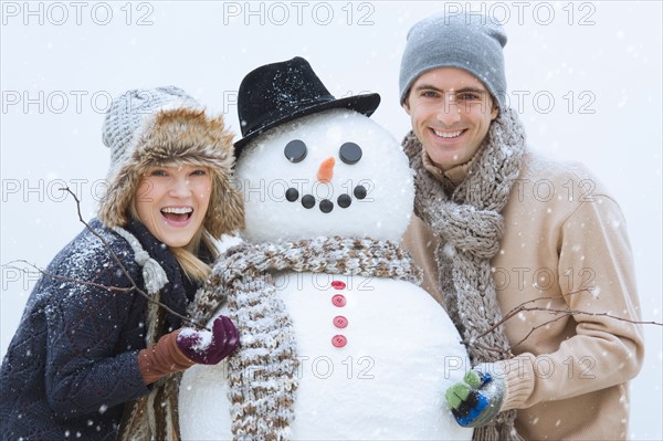 Portrait of couple with snowman.