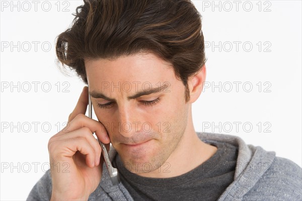 Studio portrait of man talking on mobile phone.