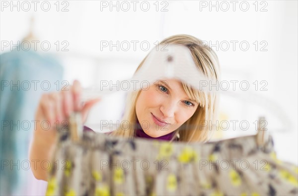 Woman looking at skirt in clothes store.