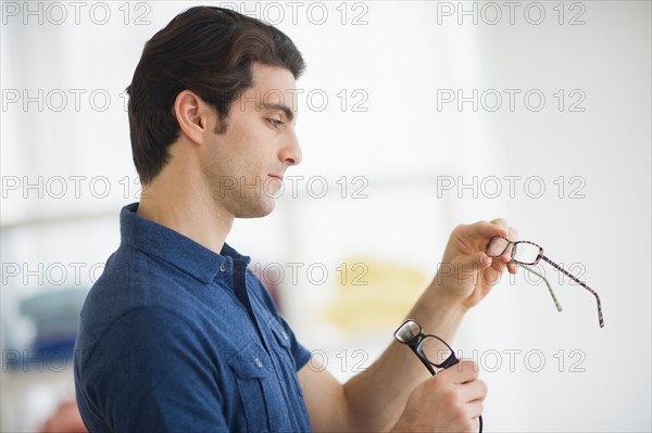 Man looking at spectacles in store.