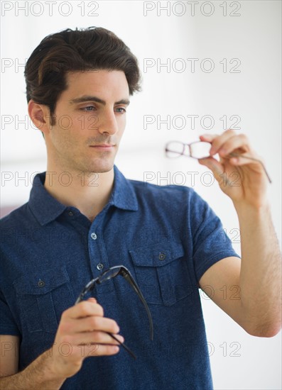 Man looking at spectacles in store.