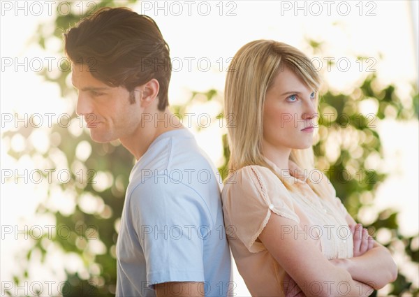 Angry couple standing back to back.