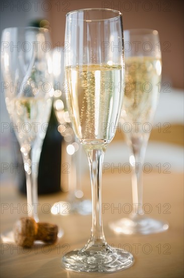 Champagne flutes and cork on table. Photo : Jamie Grill