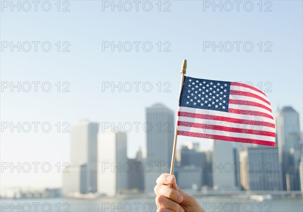 USA, New York State, New York City, Manhattan, Hand holding American flag. Photo : Jamie Grill