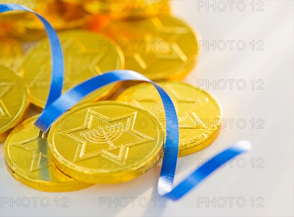 Studio Shot of chocolate coin and blue ribbon. Photo : Daniel Grill