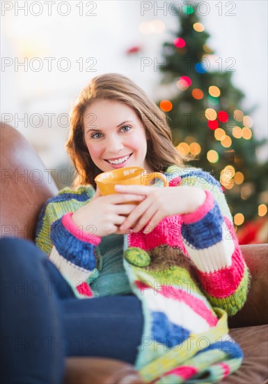 Young woman relaxing on sofa. Photo : Daniel Grill