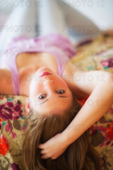 Young attractive woman lying on bed. Photo : Daniel Grill