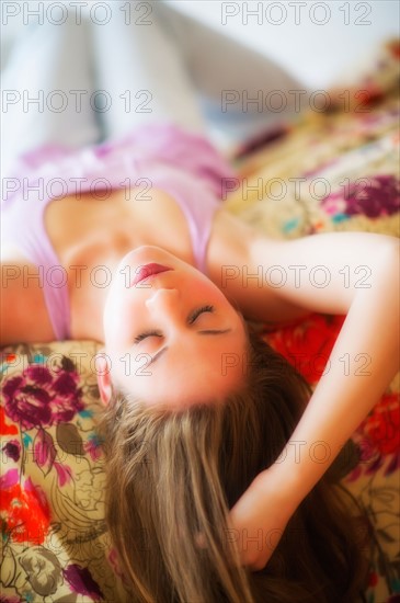 Young attractive woman lying on bed. Photo : Daniel Grill