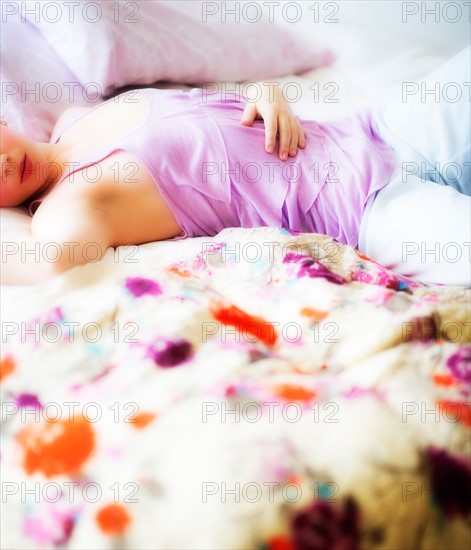 Young attractive woman lying on bed. Photo : Daniel Grill