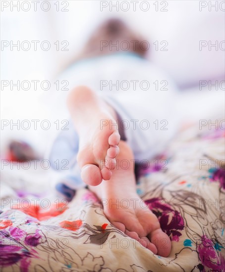 Close-up of woman's feet lying on bed. Photo : Daniel Grill