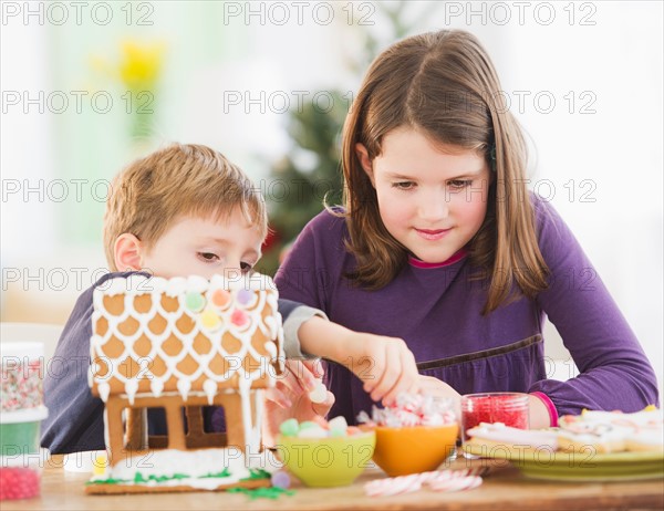 Girl (8-9) and boy (6-7) preparing gingerbread decorations. Photo : Daniel Grill