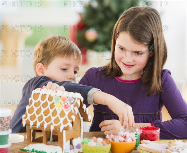 Girl (8-9) and boy (6-7) preparing gingerbread decorations. Photo : Daniel Grill