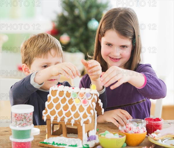 Girl (8-9) and boy (6-7) preparing gingerbread decorations. Photo : Daniel Grill