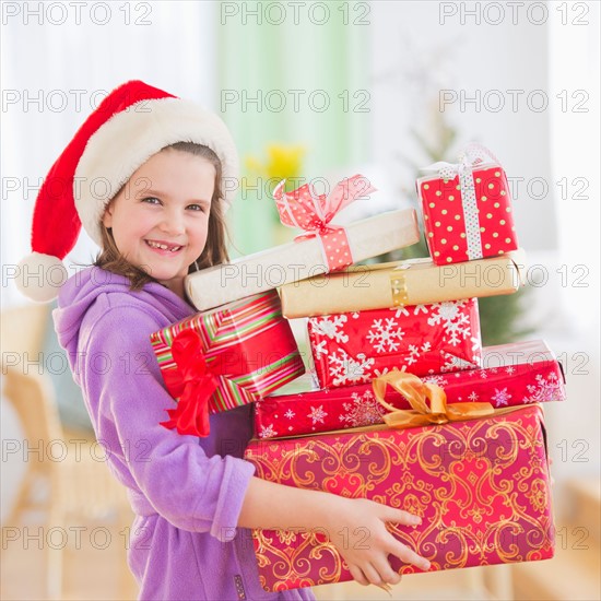 Girl (8-9) carrying christmas gifts. Photo : Daniel Grill