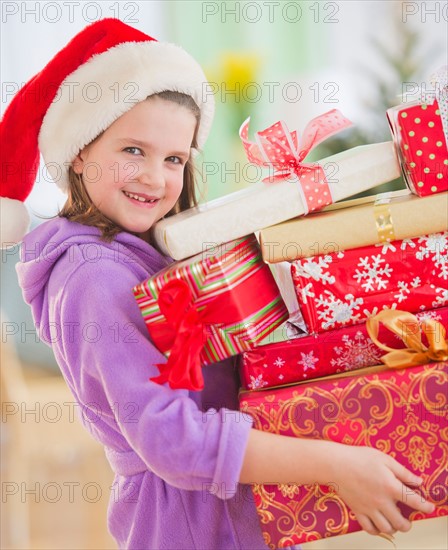 Girl (8-9) carrying christmas gifts. Photo : Daniel Grill