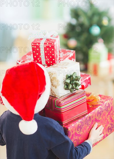 Boy (6-7) carrying christmas gifts. Photo : Daniel Grill