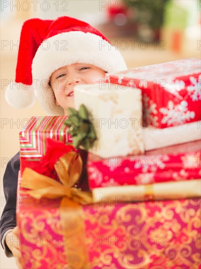 Boy (6-7) carrying christmas gifts. Photo : Daniel Grill