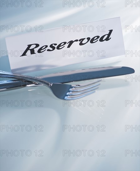 Studio shot of silverware and Reserved sign. Photo : Daniel Grill