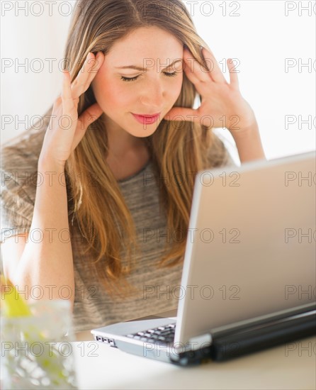 Portrait of young woman working with laptop. Photo : Daniel Grill