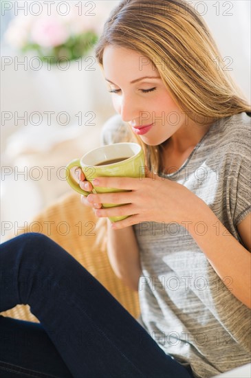 Portrait of young woman with mug. Photo : Daniel Grill