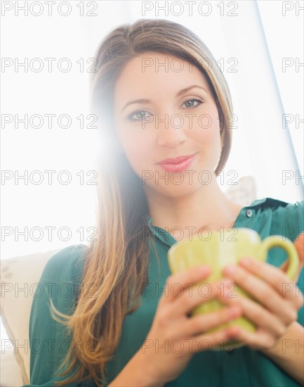 Portrait of young woman with mug. Photo : Daniel Grill