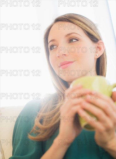 Portrait of young woman with mug. Photo : Daniel Grill
