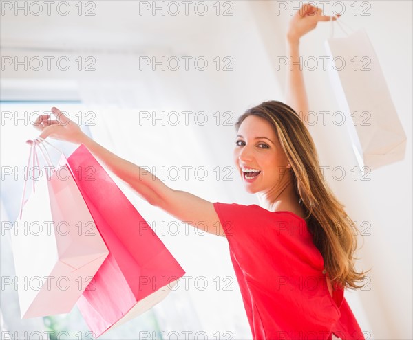 Portrait of young woman with shopping bags. Photo : Daniel Grill