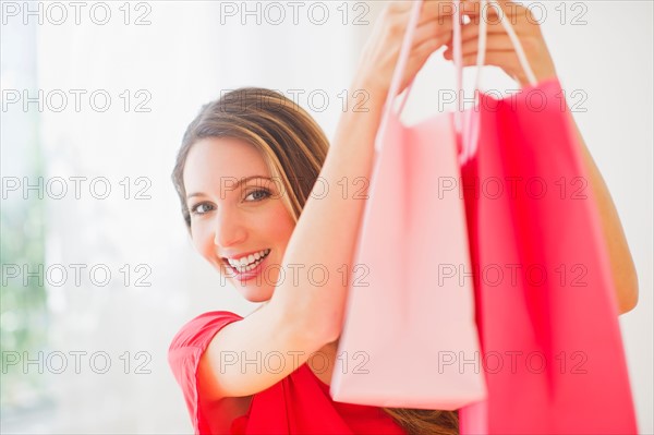 Portrait of young woman with shopping bags. Photo : Daniel Grill