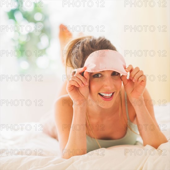 Portrait of young woman lying on bed. Photo : Daniel Grill