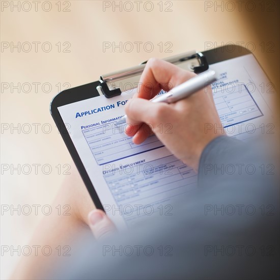 Young woman filling application form. Photo : Daniel Grill