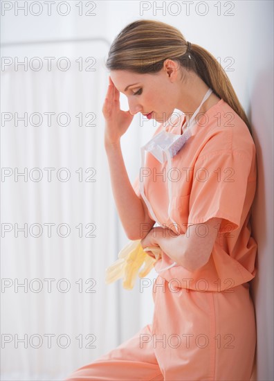 Female doctor leaning to wall. Photo : Daniel Grill