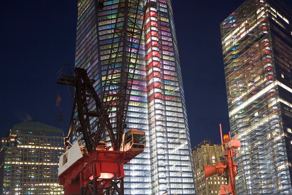 USA, New York State, New York City, crane in front of illuminated skyscrapers. Photo : fotog