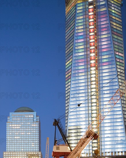 USA, New York State, New York City, crane in front of illuminated skyscrapers. Photo : fotog