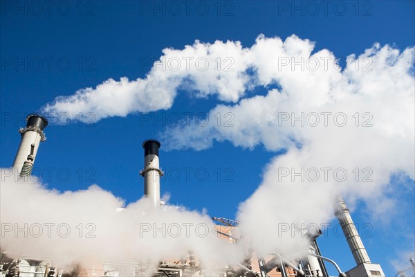 low angle view of factory chimneys. Photo : fotog