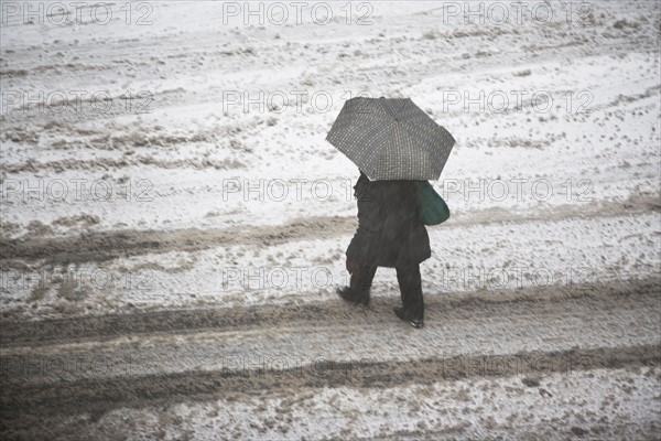 USA, New York State, New York City, pedestrian walking with umbrella. Photo : fotog