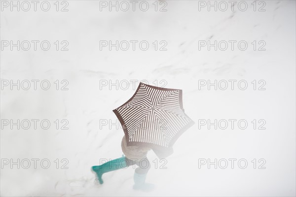 USA, New York State, New York City, pedestrian walking with umbrella. Photo : fotog