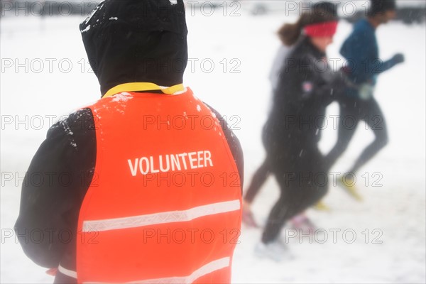 Volunteer assisting in marathon race. Photo : fotog