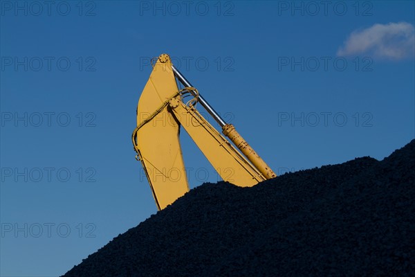 Part of crane behind coal stack. Photo : fotog