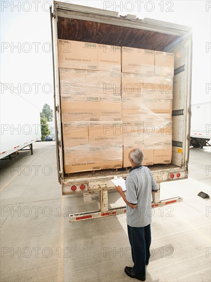 Man checking load on truck trailer.