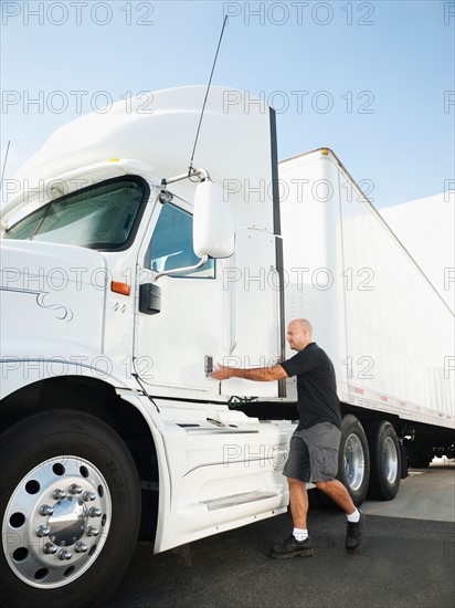 Truck driver entering truck.