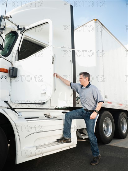 Truck driver entering truck.