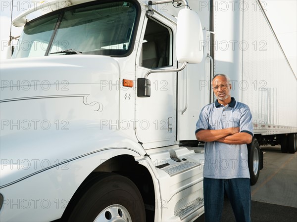 Truck driver standing near truck.