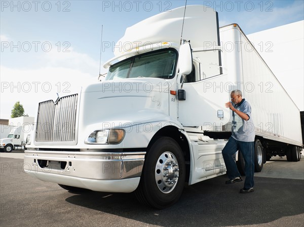 Truck driver entering truck.