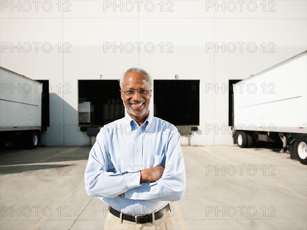 Portrait of businessman outside warehouse.